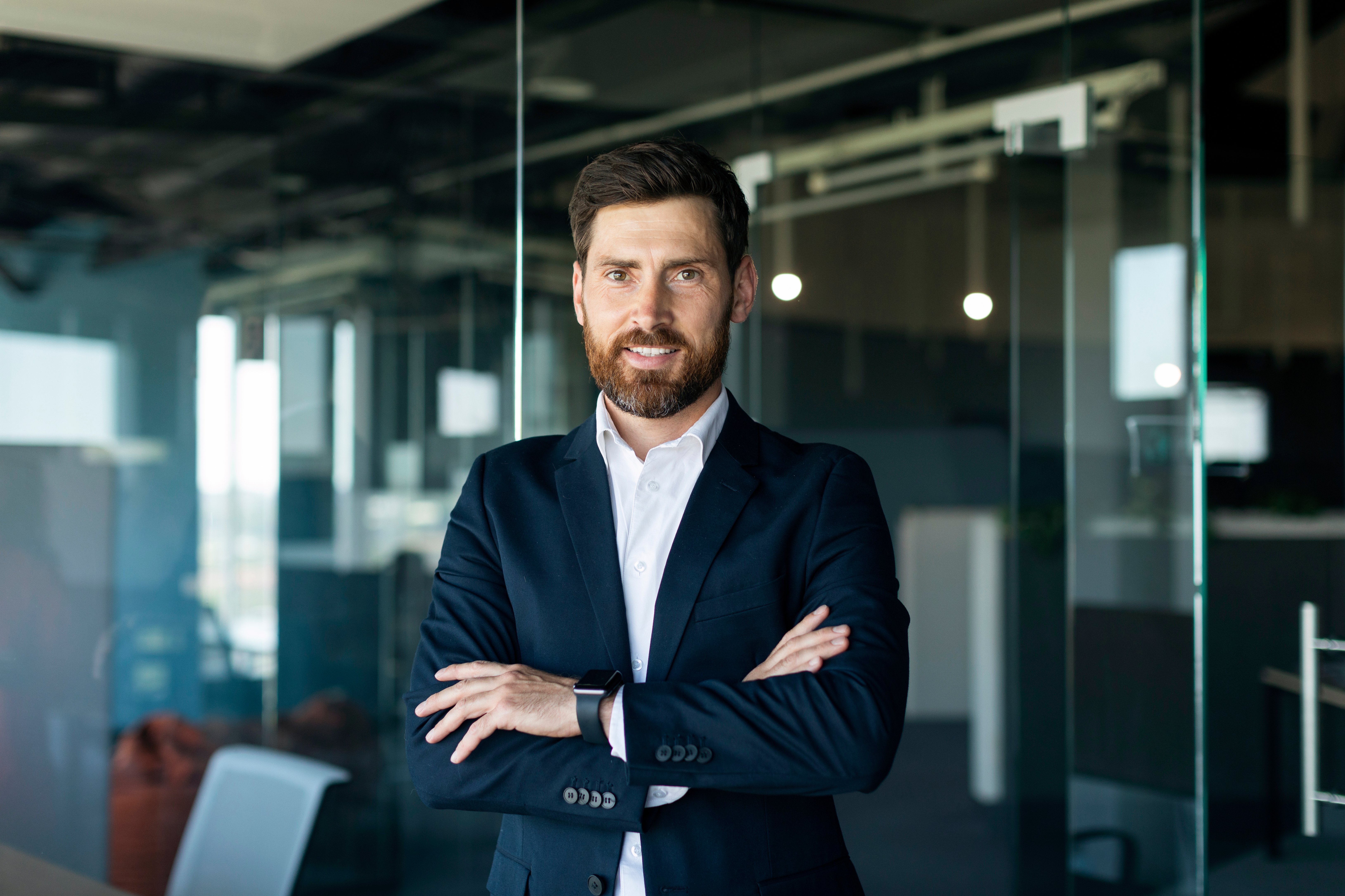 portrait-confident-smiling-middle-aged-businessman-formal-wear-posing-with-crossed-hands-office-interior